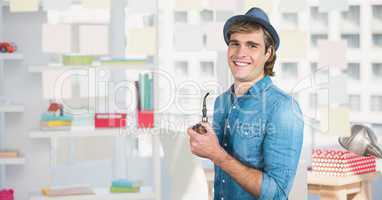 Male hipster smiling while holding smoking pipe