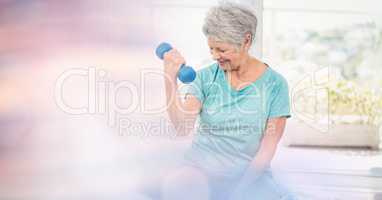 Senior woman lifting dumbbells in gym