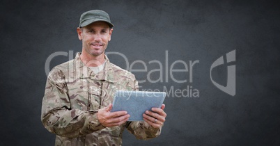 Soldier with tablet against grey background with grunge overlay