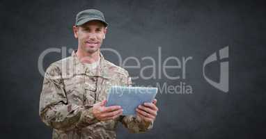 Soldier with tablet against grey background with grunge overlay