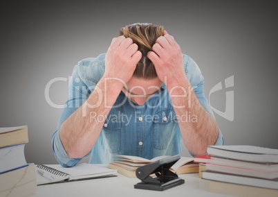Man stressed at desk against grey background