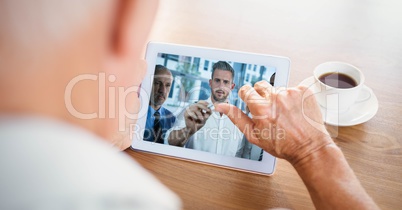 Cropped image of businessman video conferencing with partners on tablet PC