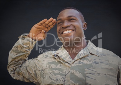 Soldier smiling and saluting against navy background