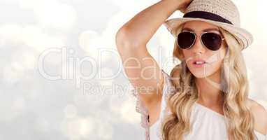 Beautiful woman wearing sunhat and sunglasses over bokeh