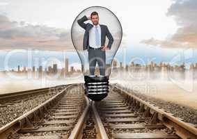 Confused businessman in light bulb over tracks