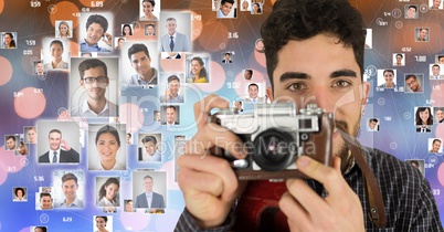 Confident male photographer holding camera surrounded by flying portraits over bokeh