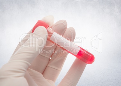 Gloved hand with red container against white wall