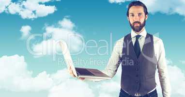 Hipster holding laptop against sky