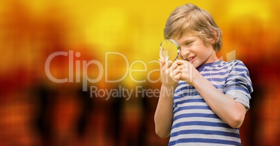 Curious boy looking through magnifying glass over bokeh