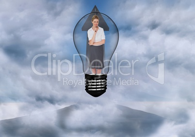 Businesswoman standing in bulb against sky