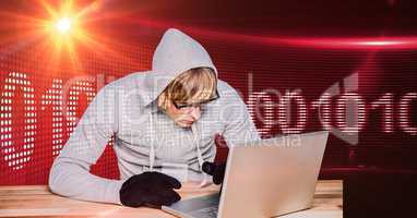 Hacker using laptop with binary code in background