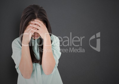 Girl with hands on face against grey wall
