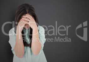 Girl with hands on face against grey wall