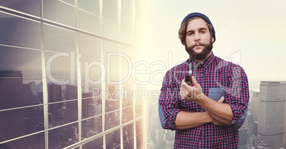 Portrait of businessman holding tobacco pipe against buildings