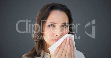 Close up of woman with tissue against grey background