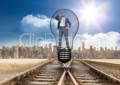 Digital composite image of businessman in light bulb over tracks