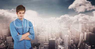 Confident hipster with arms crossed against city