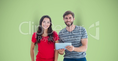 Portrait of male and female hipsters with digital tablet against green background