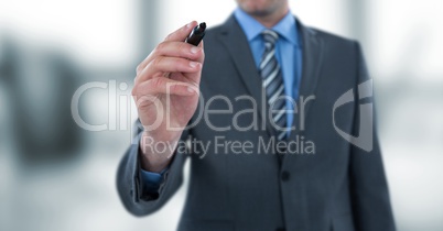 Midsection of businessman writing with felt tip pen on imaginary screen