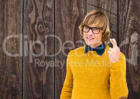 Portrait of smiling male hipster crossing fingers against wooden wall