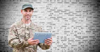 Soldier with tablet against white brick wall
