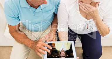 Senior couple video conferencing on tablet PC