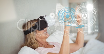 Digital composite image of woman touching futuristic screen while using VR glasses at home