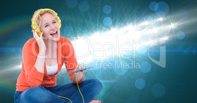 Young woman singing and listening to songs on headphones