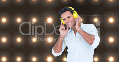 Happy man listening to music with lights in background