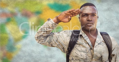 Soldier with backpack saluting against blurry map and grunge overlay