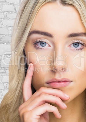 Close up of woman thinking against white brick wall