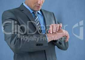 Midsection of businessman touching wrist over blue background