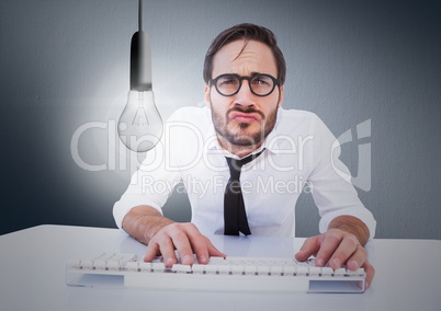 Business at desk with glowing lightbulb against navy background