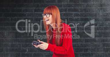 Redhead hipster playing video game against wall