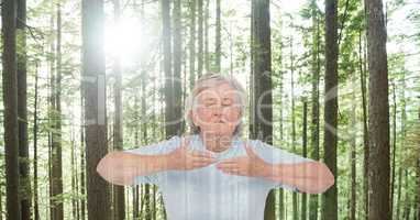 Double exposure senior woman meditating in forest