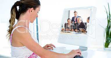 Woman video conferencing with business people