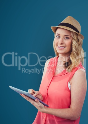 Portrait of smiling woman holding digital tablet against blue background