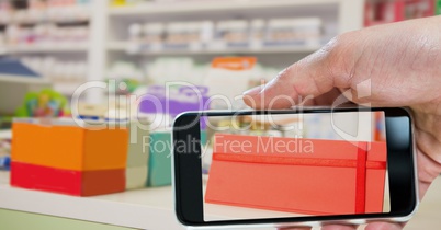 Hand taking picture of envelope with smart phone in store
