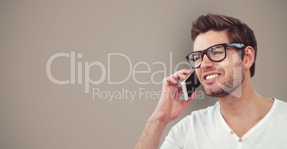 Male hipster using smart phone against brown background