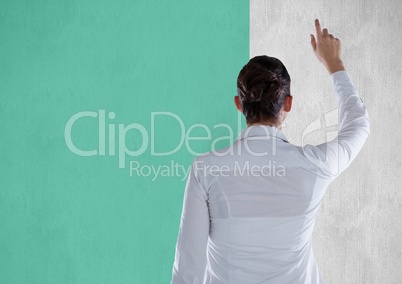 Rear view of businesswoman pointing on bill board against turquoise background