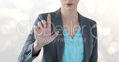 Midsection of businesswoman touching imaginary screen over bokeh