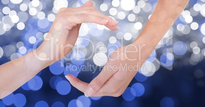 Cropped image of hands against glowing bokeh