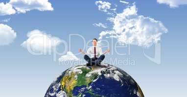Businessman doing meditation on earth against sky