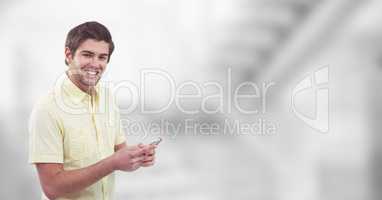 Smiling man holding mobile phone over blur background