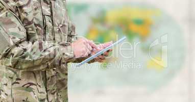 Soldier mid section with tablet against blurry map