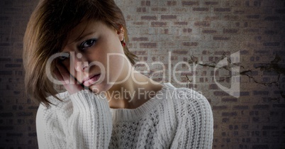 Woman sad face and head in hand against brown brick wall