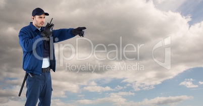 Security guard using radio against cloudy sky