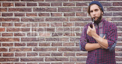 Hipster smoking pipe against brick wall