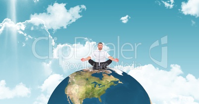 Businessman meditating on globe against sky