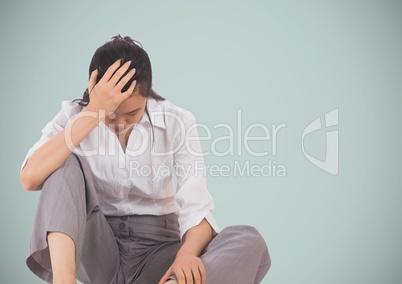 Stressed business woman sitting against light blue background